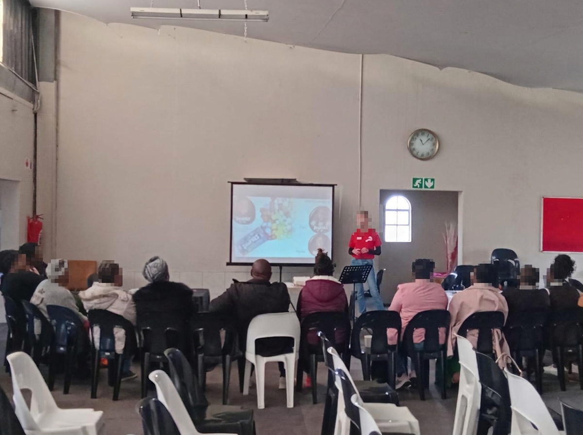 A volunteer facilitating an Alpha session in the church hall