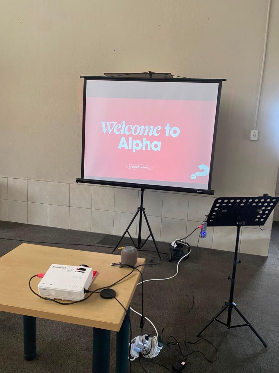 The projector screen showing “Welcome to Alpha”